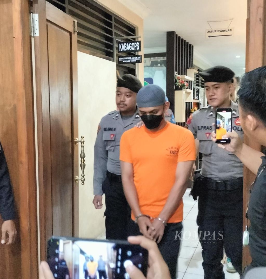 AF (22), pelatih bela diri yang menjadi tersangka pelaku penganiayaan mahasiswa di Instiper Yogyakarta, saat digiring polisi di Polresta Sleman, Rabu (8/5/2024).