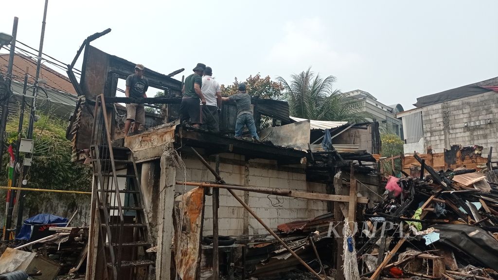 Warga membersihkan puing kebakaran di RT 008 RW 008 Jalan Simprug Golf II, Kelurahan Grogol Selatan, Kecamatan Kebayoran Lama, Jakarta Selatan, Rabu (24/8/2022).