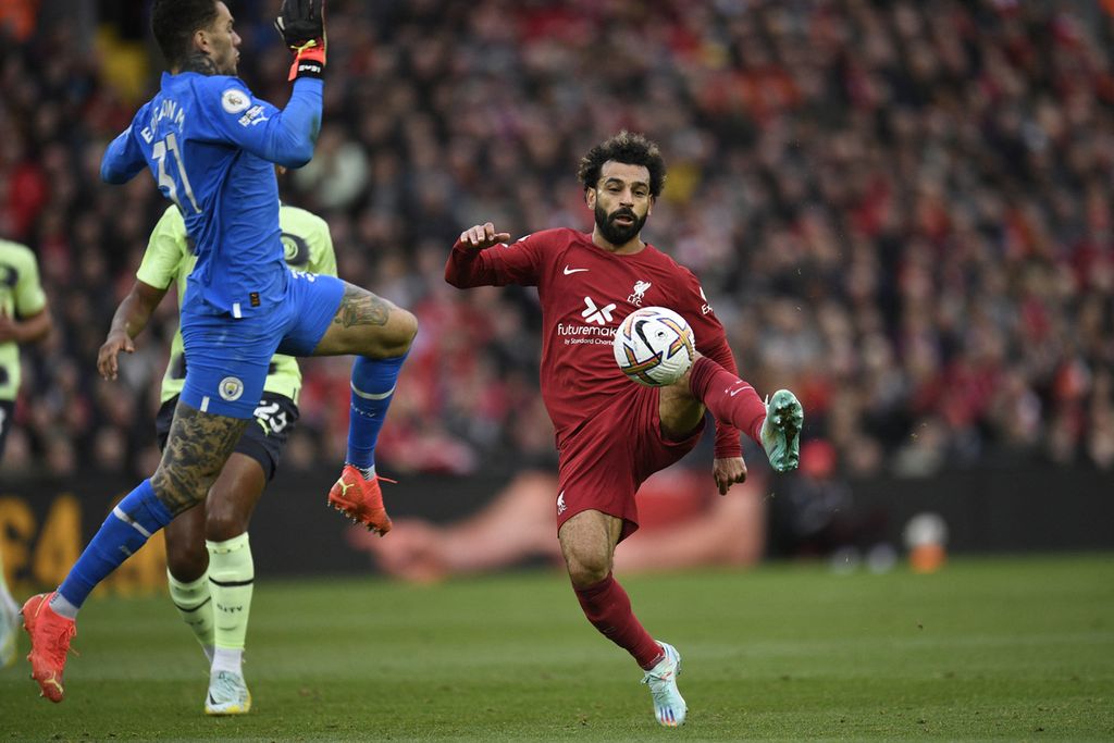 Penyerang Liverpool, Mohamed Salah (kanan), berupaya mengecoh kiper Manchester City, Ederson (kiri), pada laga Liga Inggris di Stadion Anfield, Minggu (16/10/2022). Liverpool menang, 1-0. 