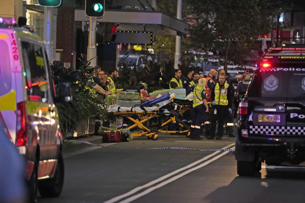 Petugas tanggap darurat bersiaga di dekat peralatan mereka di luar mal Westfield Bondi Junction, Sydney setelah insiden penikaman yang menewaskan enam orang pada Sabtu (13/4/2024).