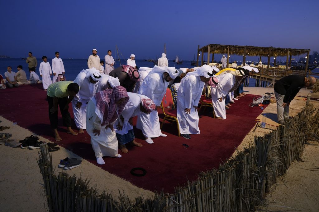 Beberapa warga melaksanakan shalat di tempat terbuka di Pantai Katara, Doha, Qatar, Senin (28/12/2022). Selama perhelatan Piala Dunia 2022, banyak turis asing mendatangi masjid atau tempat-tempat bersejarah untuk mengenal lebih jauh tentang Islam dan kehidupan masyarakat Qatar. 
