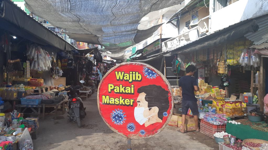 Peringatan wajib mengenakan masker terpasang di dalam kompleks Pasar Inpres Naikoten, Kota Kupang, NTT, Rabu (21/7/2021). Tampak seorang pedagang (membelakangi), tidak mengenakan masker.