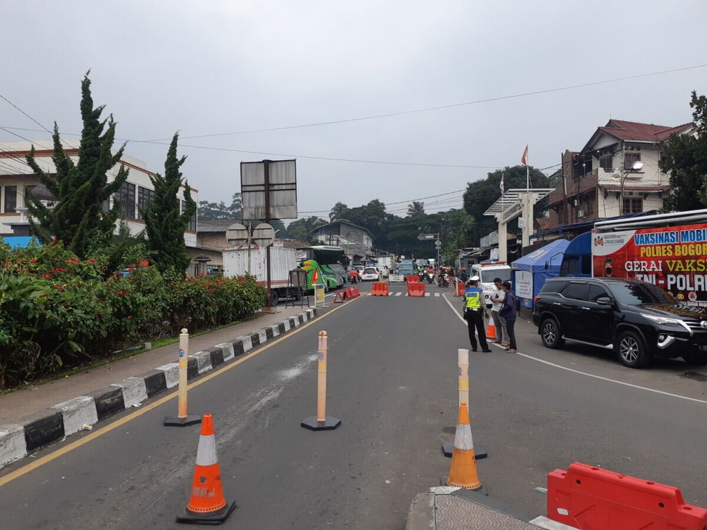Petugas Satuan Lalu Lintas Kepolisian Resor Bogor menutup jalur arah Puncak, Kamis (30/12/2021). 