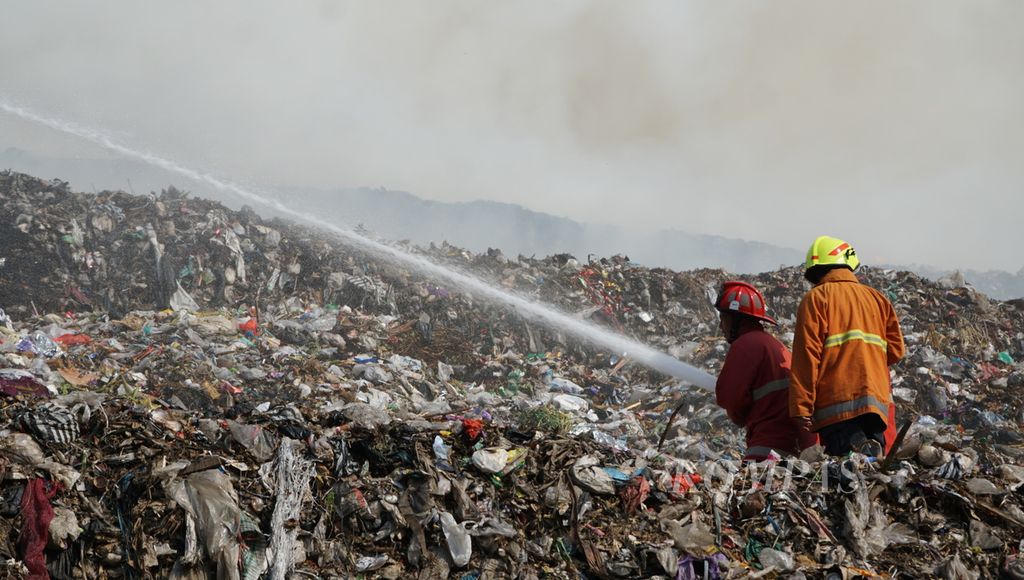 Petugas berupaya memadamkan kobaran api yang muncul pada tumpukan sampah yang menggunung di TPA Putri Cempo, Kota Surakarta, Jawa Tengah, Sabtu (16/9/2023). 