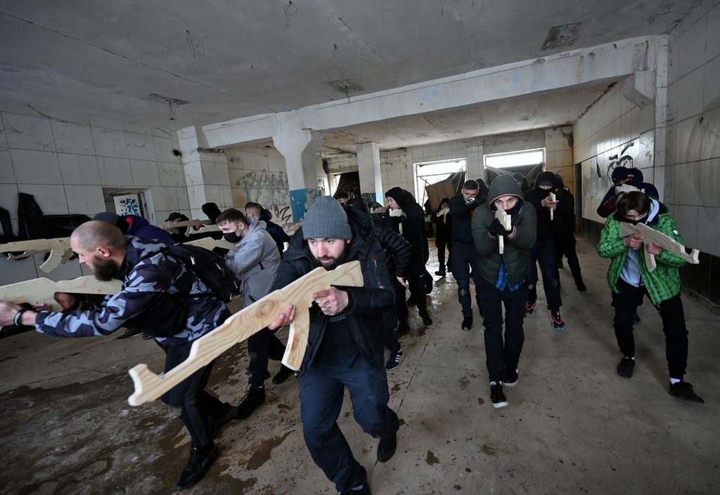 Sejumlah warga sipil memegang replika kayu senapan Kalashnikov ketika mengikuti latihan tempur warga sipil di sebuah pabrik yang terbengkalai di Kiev, Ukraina, Minggu (6/2/2022). Selain ancaman militer, warga Ukraina juga beberapa kali harus menanggung akibat serangan siber di negara itu.