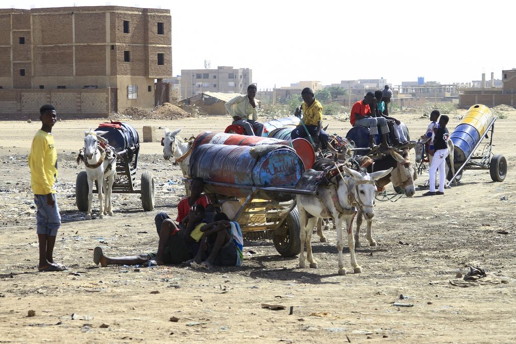Sejumlah warga mengisi tangki-tangki dengan air di Khartoum selatan, 22 April 2023. Persediaan air kian menipis di tengah pertempuran antara dua faksi militer di Sudan.  