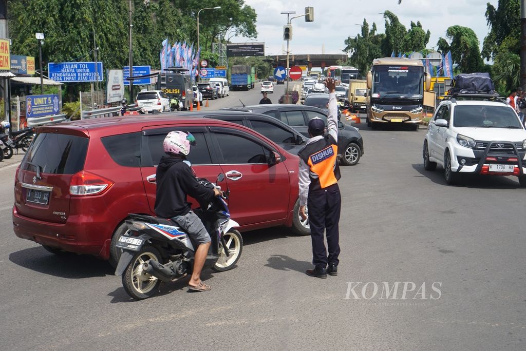 Petugas mengatur kendaraan di pintu keluar Tol Merak menuju Pelabuhan Merak, Sabtu (6/4/2024).