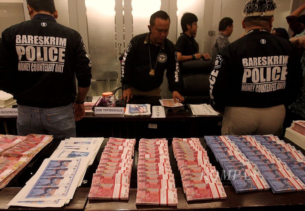 Ribuan lembar uang palsu pecahan Rp 50.000 dan Rp 100.000 beserta alat cetaknya ditunjukkan petugas kepolisian saat digelarnya konferensi pers di Bareskrim Polri, Jakarta, Jumat (22/7/2016).