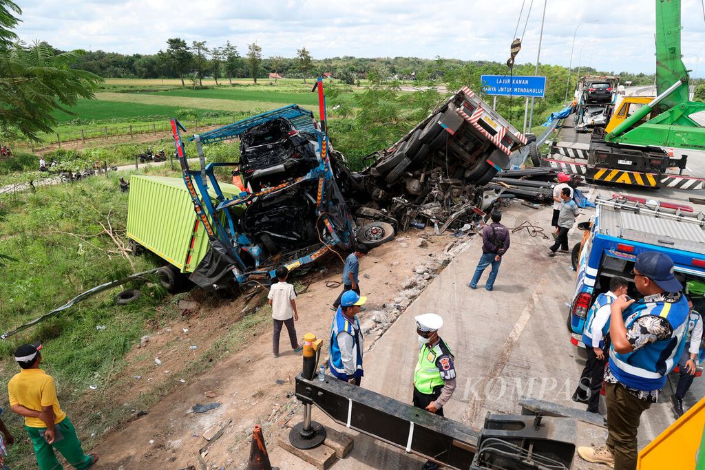 Petugas mengawasi proses evakuasi empat truk yang mengalami kecelakaan setelah tabrakan beruntun di jalan tol Semarang-Surakarta, Kabupaten Boyolali, Jawa Tengah, Jumat (14/4/2023). 