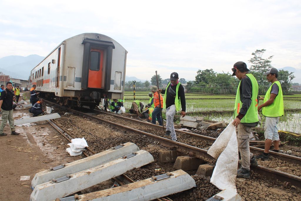 Sejumlah pekerja memperbaiki bantalan beton di rel kereta di titik kecelakaan kereta api antara KA Turangga dan KA Commuterline Bandung Raya setelah dilewati KA Lodaya di Kecamatan Cicalengka, Kabupaten Bandung, Jawa Barat, Sabtu (6/1/2024) pagi.