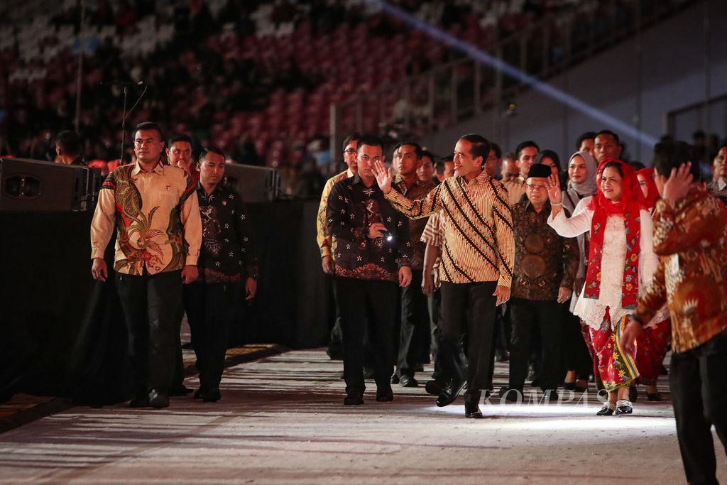 Presiden Joko Widodo (kiri) dan Ibu Negara Iriana (kanan) melambaikan tangan kepada peserta yang akan bermain angklung untuk memecahkan rekor pergelaran angklung terbesar di dunia di Stadion Utama Gelora Bung Karno, Jakarta, Sabtu (5/8/2023). 