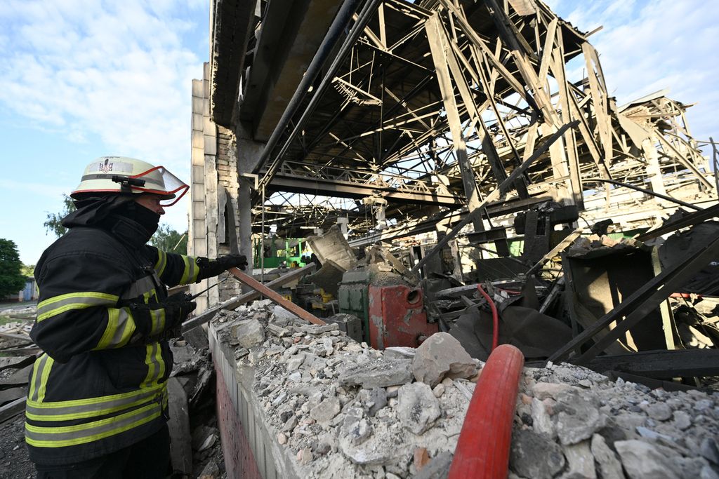 Seorang pemadam kebakaran berdiri di dekat depot produksi di pabrik perbaikan gerbong di Darnytsia yang disasar serangan rudal Rusia di Kiev, Ukraina, 5 Juni 2022. 