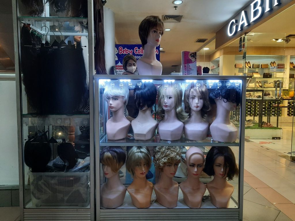 Sederet rambut palsu sintetis milik Fitri (39) yang akrab disapa Astika berdasarkan nama salonnya di Mal Harco, Pasar Baru, Jakarta, Jumat (17/2/2023). Ia menjual wig tersebut seharga Rp 100.000 bagi penyintas kanker dari harga normal Rp 150.000.