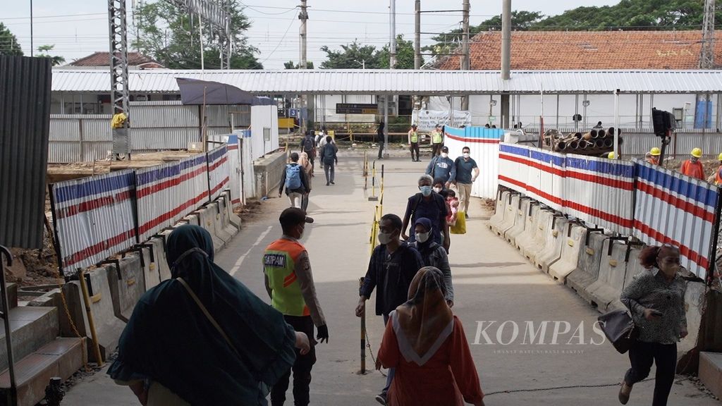 Penumpang KRL menyeberang rel saat hendak berganti peron di Stasiun Manggarai, Jakarta, Selasa (24/5/2022). Mulai Sabtu (28/5/2022), penumpang tidak perlu menyeberang rel saat akan berganti peron karena perpindahan peron berlangsung vertikal.