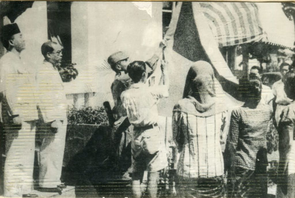 Upacara penaikan bendera sang merah putih di halaman gedung pegangsaan timur 56. Tampak, antara lain Bung Karno, Bung Hatta, Letkol Latief Hendraningrat (menaikkan bendera), Ny. Fatmawati Sukarno, dan Ny.S.K Trimurti.