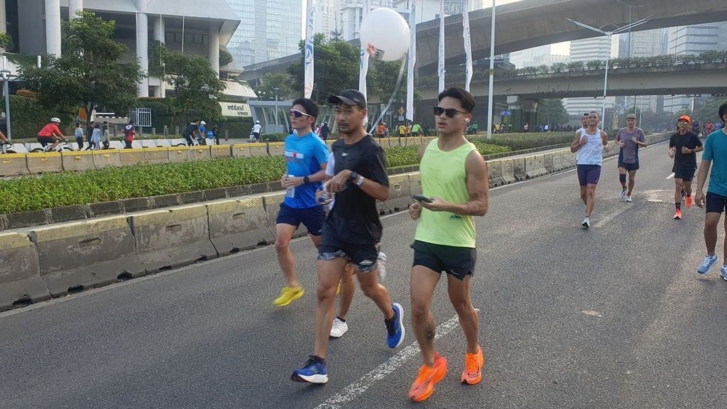 Ratusan pelari dari berbagai komunitas mengikuti acara Run The Ground with The Pacer sejauh 18 kilometer mengitari Jalan Sudirman-Thamrin, Minggu (18/6/2023). 