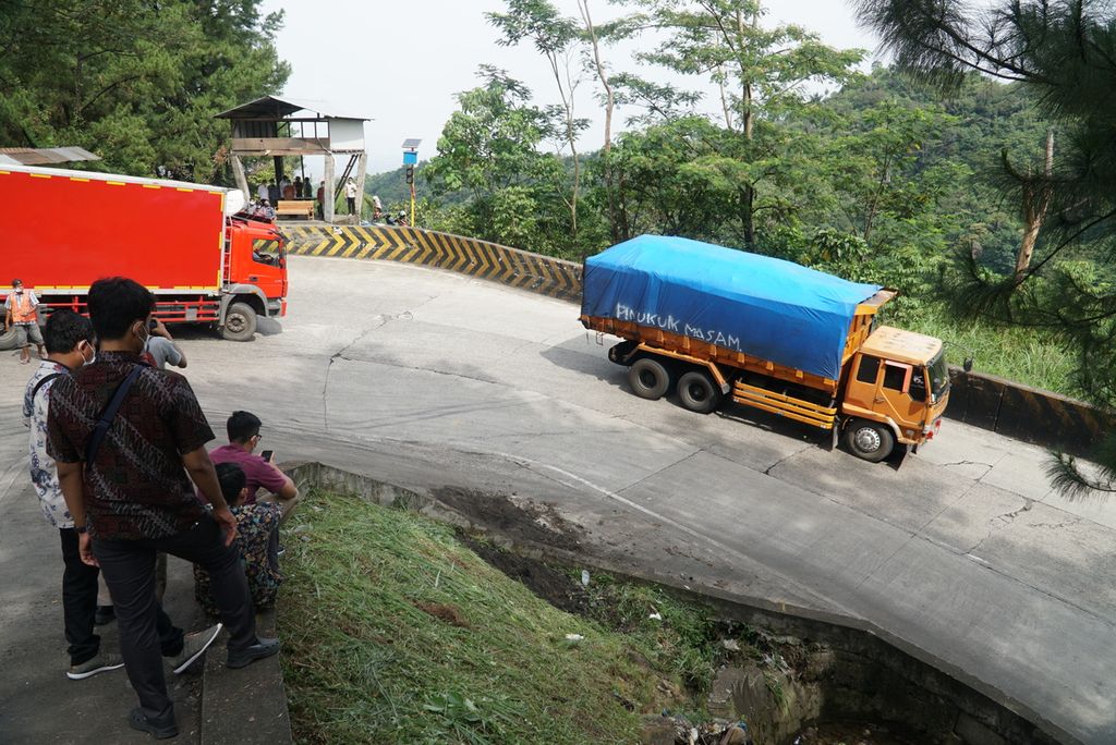Warga menyaksikan truk melintas di tikungan Panorama I Sitinjau Lauik, jalan nasional Padang-Solok, di Kecamatan Lubuk Kilangan, Kota Padang, Sumatera Barat, Kamis (8/4/2021). 