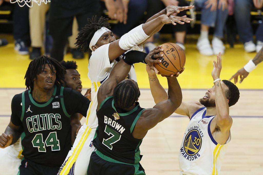 Pemain Boston Celtics Jaylen Brown (7) diadang oleh pemain Golden State Warriors Kevon Looney (atas) pada paruh kedua gim ke lima Final NBA di Chase Center, San Francisco, Amerika Serikat, Selasa (14/6/2022) pagi WIB. 