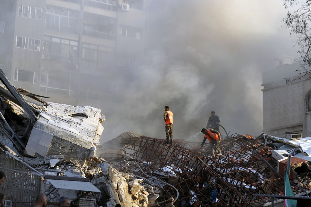 Dalam foto yang dirilis kantor berita Suriah (SANA) terlihat petugas penyelamat tengah menyingkirkan reruntuhan bangunan yang hancur akibat serangan udara Israel di Damaskus, Suriah, Senin (1/4/2024) waktu setempat.