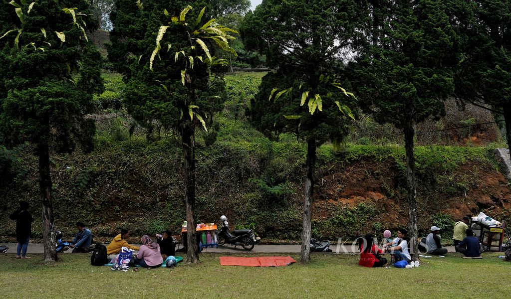 Warga beristirahat di taman kecil sekitar kawasan wisata Gunung Mas, Puncak, Kabupaten Bogor, Jawa Barat, untuk melepas lelah dari perjalanan berwisatanya, Senin (16/9/2024). Kawasan Puncak diserbu warga yang berlibur seiring hari libur nasional Maulid Nabi. 