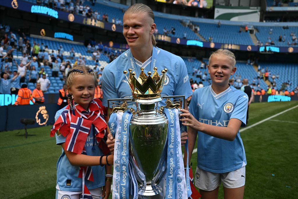 Pemain Manchester City, Erling Haaland, berpose dengan trofi juara Liga Inggris seusai pertandingan pekan terakhir Liga Inggris antara Manchester City dan West Ham United di Stadion Etihad, Manchester, Inggris, Minggu (19/5/2024). 