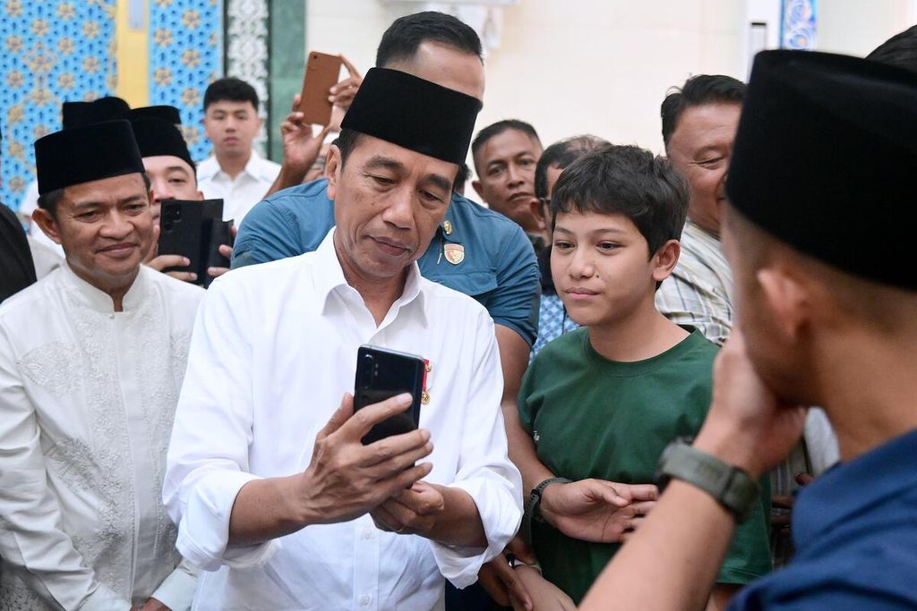 Presiden Joko Widodo berfoto bersama salah satu jemaah seusai menunaikan shalat Jumat di Masjid Agung, Kota Medan, Jumat (12/4/2024).
