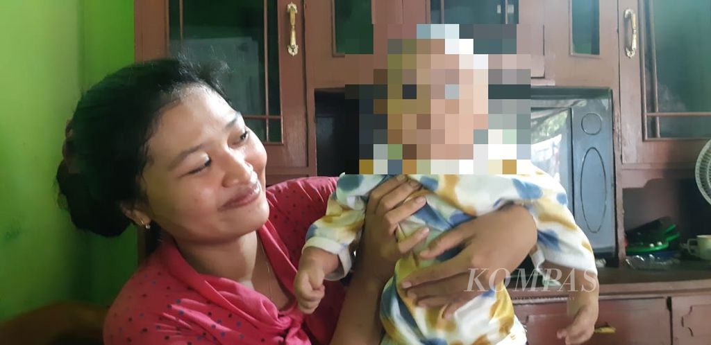 YH (27) menimang anaknya yang baru ia peroleh kembali di rumahnya di Kabupaten Probolinggo, Jawa Timur, Selasa (28/3/2023).