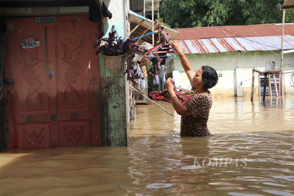 Warga beraktivitas di rumahnya yang terendam banjir di Jalan Dipanegara, Padang Bulan, Kota Medan, Sumatera Utara, Sabtu (19/11/2022). Hujan lebat pada Jumat malam membuat sejumlah permukiman dan ruas jalan di Kota Medan tergenang banjir. 