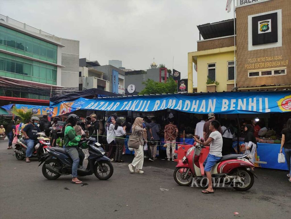 Pengendara sepeda motor dan pengunjung Bazaar Takjil Ramadhan Benhil berkerumun di Jakarta, Senin (1/4/2024).