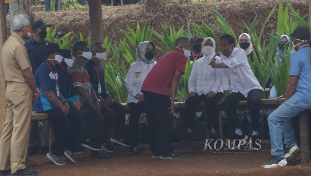 Presiden Joko Widodo (kedua dari kanan) berbincang dengan petani seusai menanam pohon kelapa genjah dalam program penanaman nasional satu juta kelapa genjah, di Desa Sanggang, Kecamatan Bulu, Kabupaten Sukoharjo, Jawa Tengah, Kamis (11/8/2022).