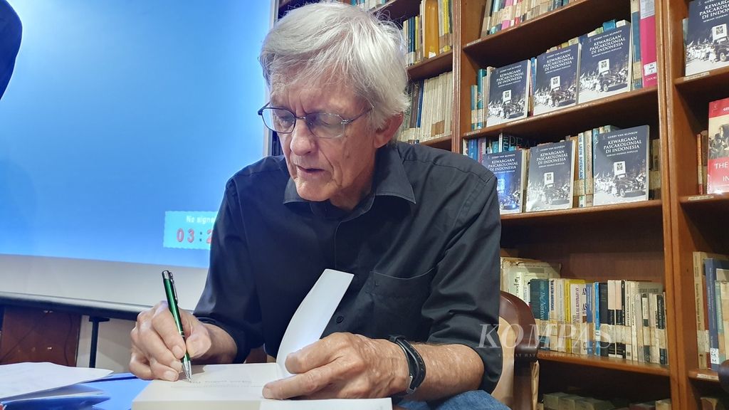 Gerry van Klinken memberikan tanda tangan dalam bukunya kepada pembaca saat peluncuran buku di Kantor Yayasan Pustaka Obor Indonesia, di Jakarta, Senin (14/8/2023). 