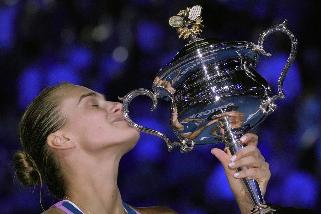 Petenis Belarus, Aryna Sabalenka, mencium trofi Daphne Akhurs Memorial setelah mengalahkan petenis Kazakhstan, Elena Rybakina, dalam final Grand Slam Australia Terbuka di Melbourne, Australia, 28 Januari 2023.  