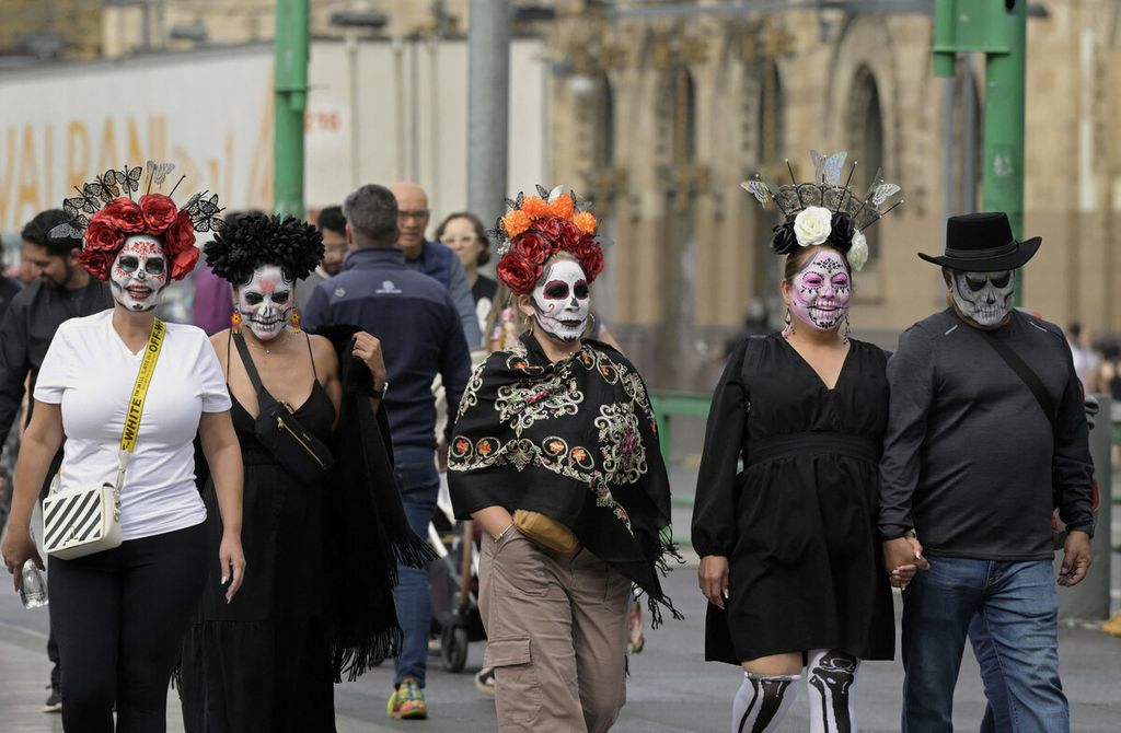Orang-orang di jalanan dengan wajah dicat "calaca" atau tengkorak saat perayaan Hari Orang Mati di Mexico City, Meksiko, Kamis (2/11/2023). 