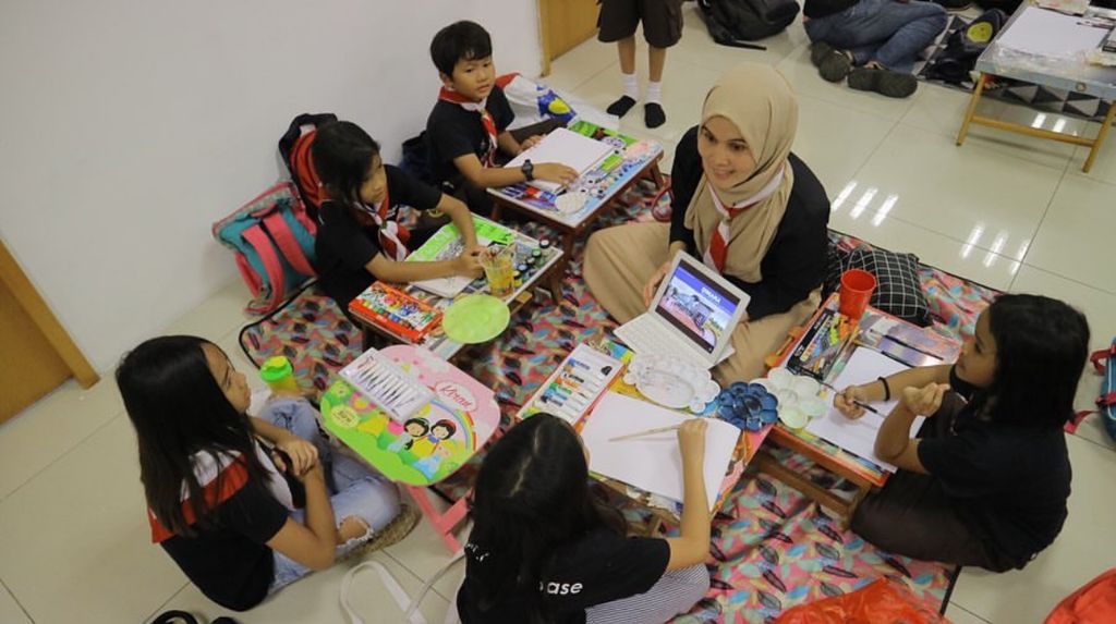 Putri Anisa ketika menemani anak-anak <i>homeschooling</i> di Klub Oase. Anak bungsunya ikut serta dalam kegiatan ini.