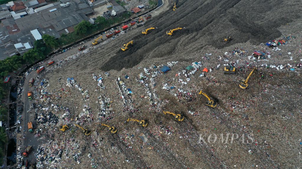 Foto udara alat berat mengangkut sampah di Tempat Pengolahan Sampah Terpadu (TPST) Bantargebang di Kota Bekasi, Jawa Barat, Selasa (6/9/2022). Jumlah sampah yang dibuang ke TPST Bantargebang saat ini 7.500 ton hingga 7.800 ton per hari.