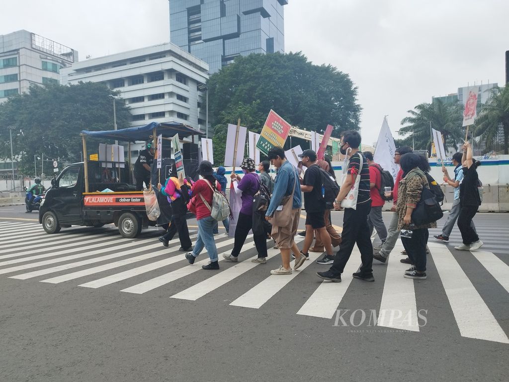 Para pekerja industri kreatif yang tergabung dalam Serikat Pekerja Media dan Industri Kreatif untuk Demokrasi (Sindikasi) menuju titik kumpul di bundaran air mancur Thamrin, Jakarta, Senin (1/5/2023), untuk memperingati Hari Buruh Sedunia.