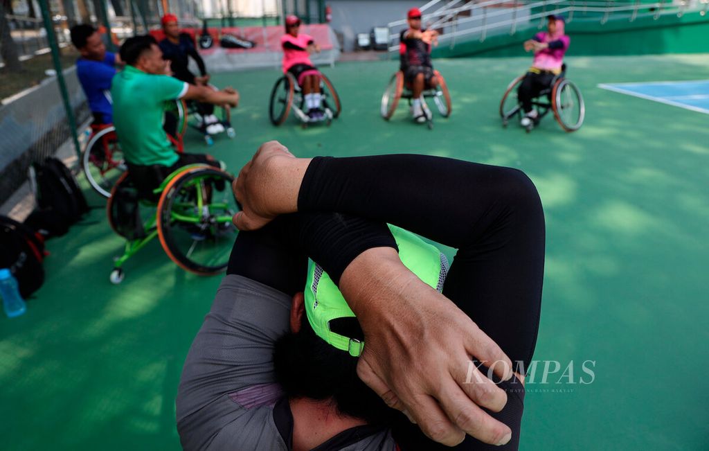 Atlet tenis kursi roda melakukan gerakan peregangan saat pemanasan sebelum berlatih untuk mengikuti ajang ASEAN Para Games 2022 di Lapangan Tenis Manahan, Kota Surakarta, Jawa Tengah, Rabu (20/7/2022). Mereka merupakan atlet difabel terbaik Indonesia untuk cabang olahraga tenis kursi roda. 