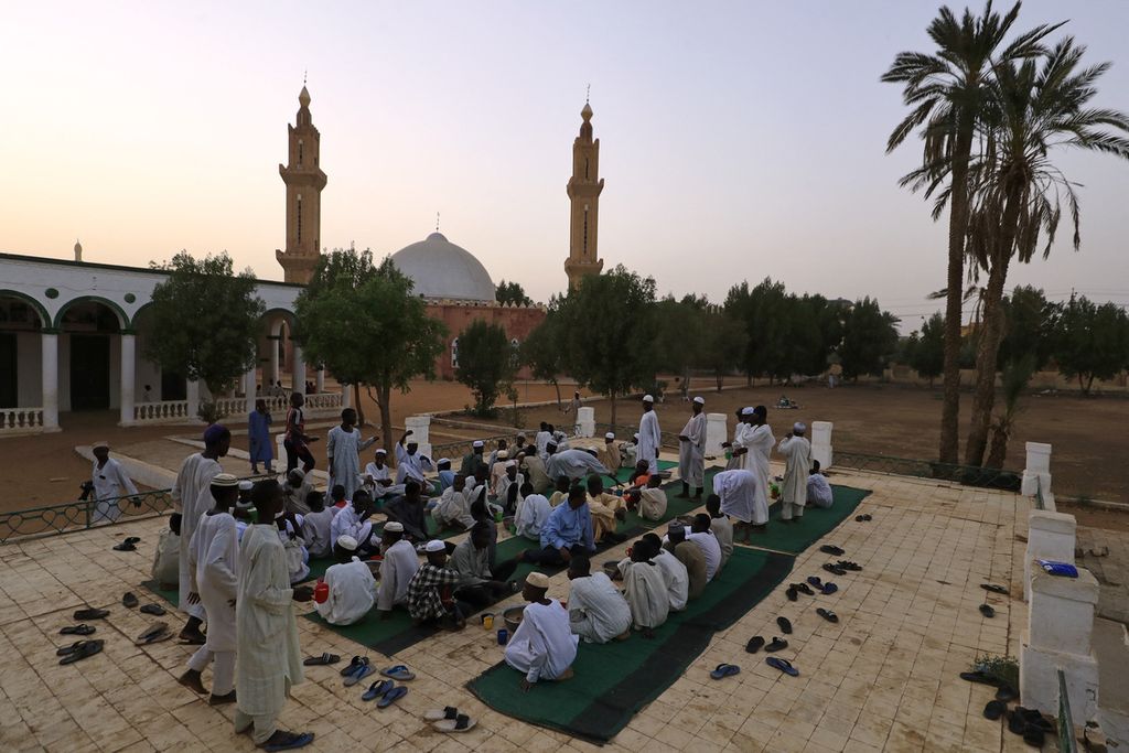 Para pria Sudan menunggu waktu berbuka puasa Ramadhan di sebuah masjid di kota kembar Omdurman, ibu kota Sudan, Senin (4/4/2022).