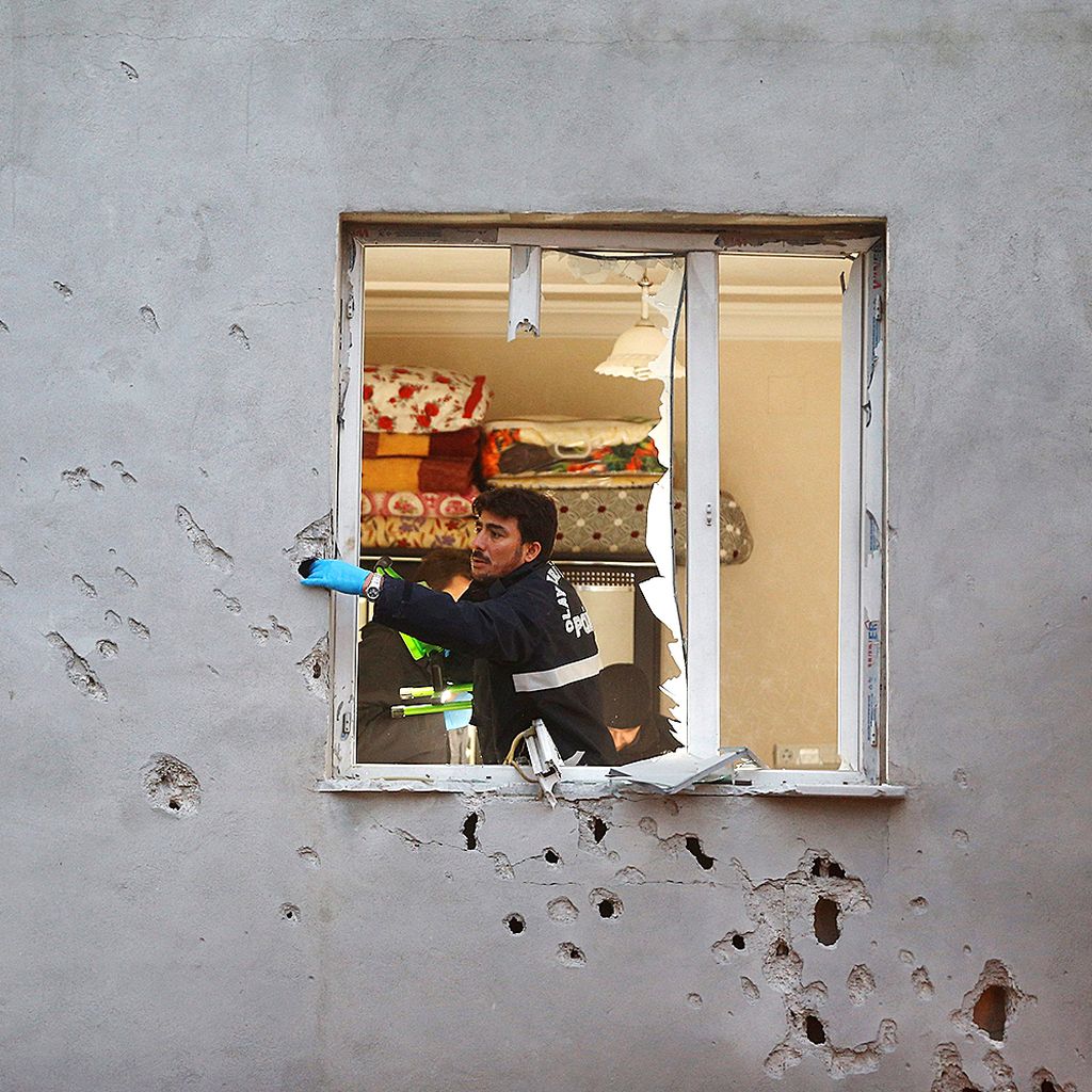 Ahli forensik  kepolisian memeriksa sebuah bangunan yang rusak terkena roket yang  ditembakkan dari wilayah Suriah dan jatuh di dekat bangunan itu di kota Kilis, Turki, yang berbatasan dengan Suriah, Senin (22/1).  