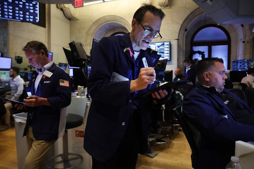 Sejumlah <i>trader</i> bekerja di lantai Bursa Saham New York atau New York Stock Exchange (NYSE) di New York City, AS, Rabu (2/8/2023). Saham Dow jatuh lebih dari 300 poin di bursa menyusul langkah Fitch Ratings menurunkan peringkat utang Pemerintah Amerika Serikat dari AAA menjadi AA+ pada Selasa (1/8/2023). 