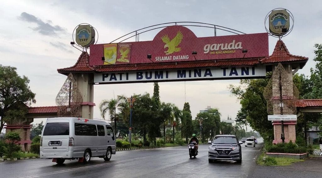 Sejumlah kendaraan melintasi gerbang Kabupaten Pati di Kecamatan Margorejo, Pati, Jawa Tengah, Sabtu (25/12/2021). Pati merupakan salah satu daerah penghasil produk pertanian. Di sana juga terdapat dua pabrik besar kacang, yakni Garuda dan Dua Kelinci.