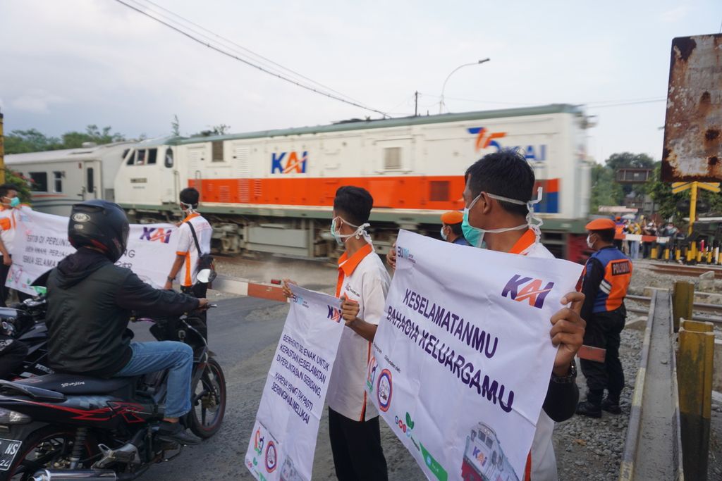 Anggota Komunitas Pencinta Kereta Api Spoor 5 memberikan sosialisasi tentang keselamatan di pelintasan sebidang di Purwokerto, Banyumas, Jawa Tengah, Selasa (27/4/2021).