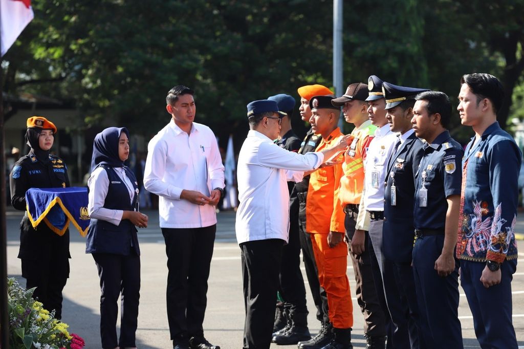 Menteri Perhubungan Budi Karya Sumadi menyematkan pin kepada petugas saat Apel Gelar Pasukan Angkutan Natal dan Tahun Baru 2023/2024 di Stasiun Gambir, Jakarta, Kamis (21/12/2023).