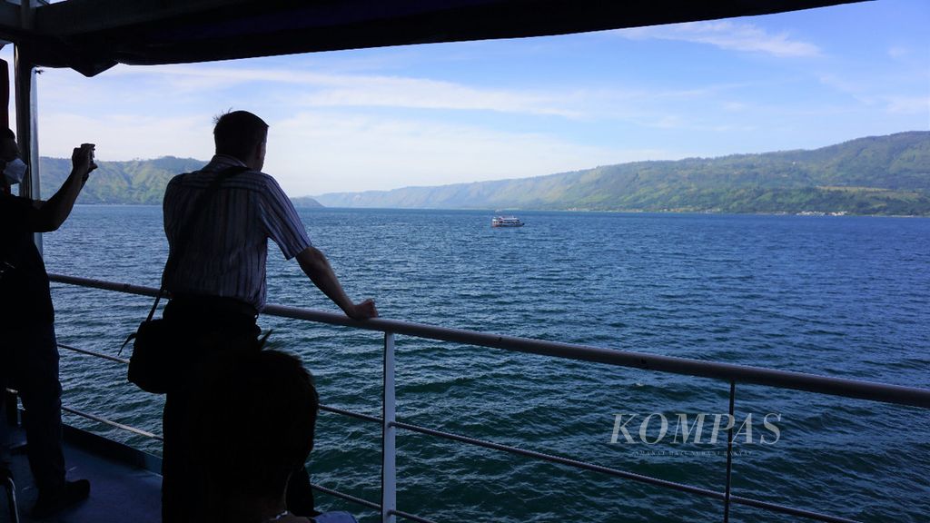 Turis dari Jerman yang sedang naik kapal feri dari Tomok, Samosir, menuju Parapat sedang melihat pemandangan di Danau Toba pada Rabu (20/7/2022).