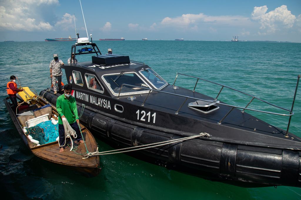 Dua nelayan asal Batam, Kepulauan Riau, didampingi Agensi Penguatkuasaan Maritim Malaysia (APMM) bersiap merapat ke Kapal Negara Bintang Laut milik Badan Keamanan Laut (Bakamla) Republik Indonesia di Perairan Pengerang, Malaysia, Senin (26/4/2021). 