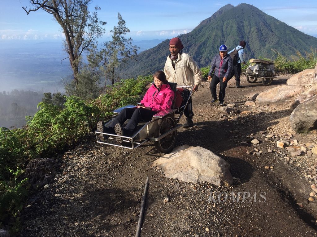 Pengunjung memanfaatkan fasilitas berbayar  troli atau gerobak untuk mendaki Kawah Ijen di Banyuwangi, Jawa Timur, Rabu (8/3/2023).