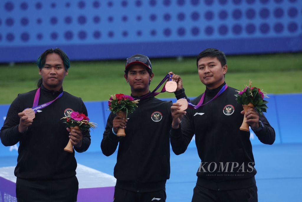 The Indonesian archery team, Arif Dwi Pangestu/Ahmad Khoirul Baasith/Riau Ega Agatha Salsabilla (from left to right), won bronze after beating Bangladesh, 6-0, in the men's team recurve event at the 2022 Asian Games in Fuyang Yinhu Sports Center, China, Friday (6/10/2023).
