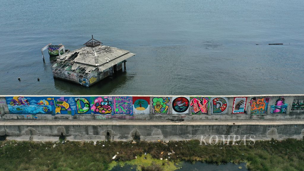 Foto udara mural berisi keresahan aktivis Jakarta Think City di tanggul pengaman pantai di Muara Baru, Jakarta Utara, Senin (24/10/2022). Sejumlah aktivis menyuarakan keresahan penurunan permukaan tanah di utara Jakarta yang berpotensi tenggelam.