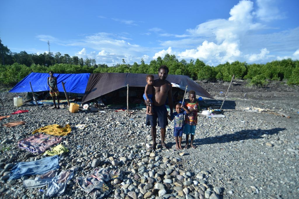 Satu keluarga suku Kamoro atau suku laut asli Kabupaten Mimika berpose di depan rumah sementaranya di kawasan Pomako, Mimika, Papua, Jumat (15/10/2021). 