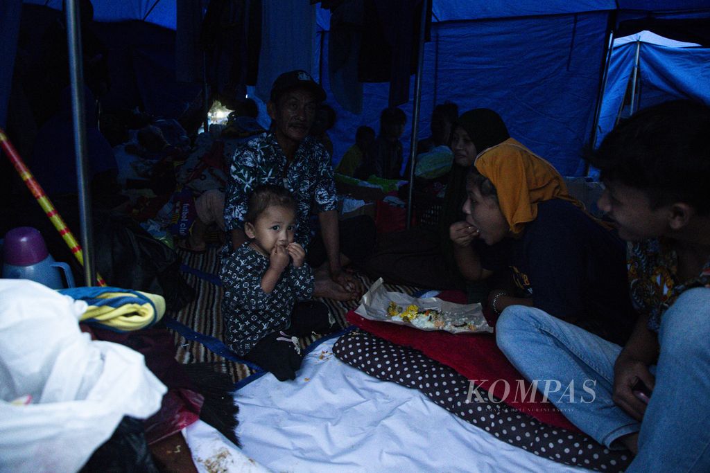 Cindi (2) menikmati makanan di dalam tenda pengungsian korban gempa bumi di Desa Mangunkerta, Kecamatan Cugenang, Kabupaten Cianjur, Jawa Barat, Kamis (24/11/2022).